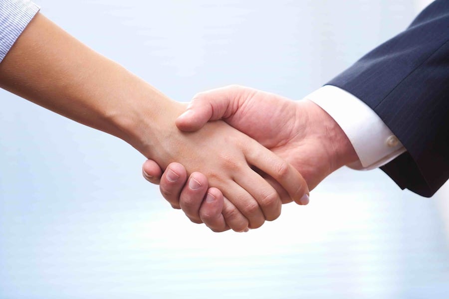 People at work: man and woman hand shaking at a meeting