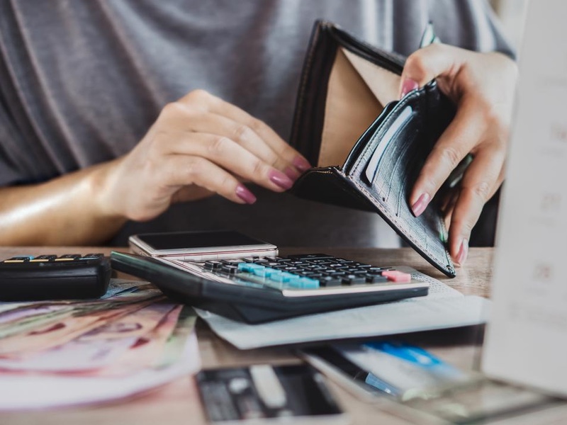 poor woman hand open empty purse looking for money for credit card debt